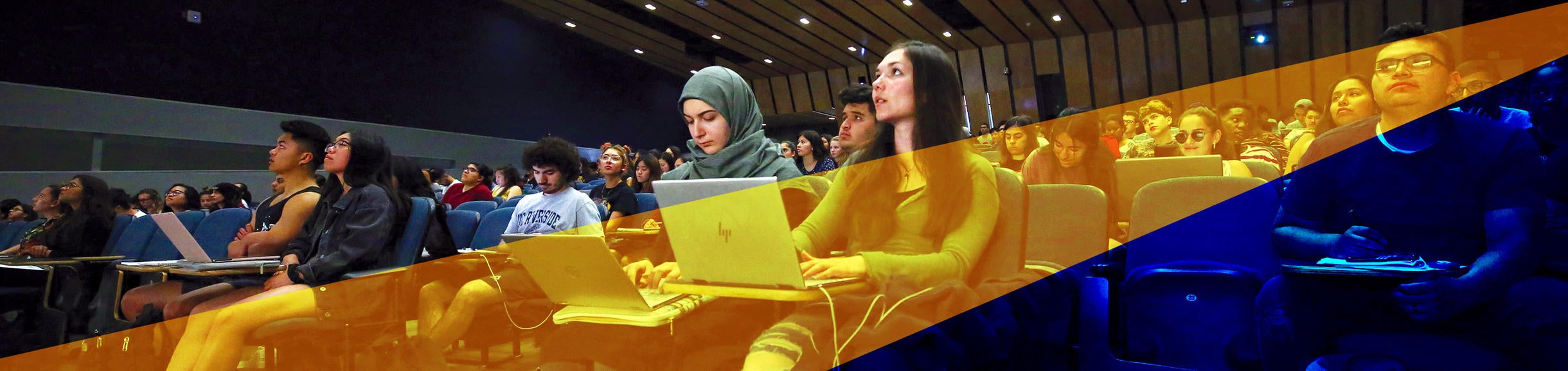 UCR students fill an on-campus lecture hall and engage in learning.